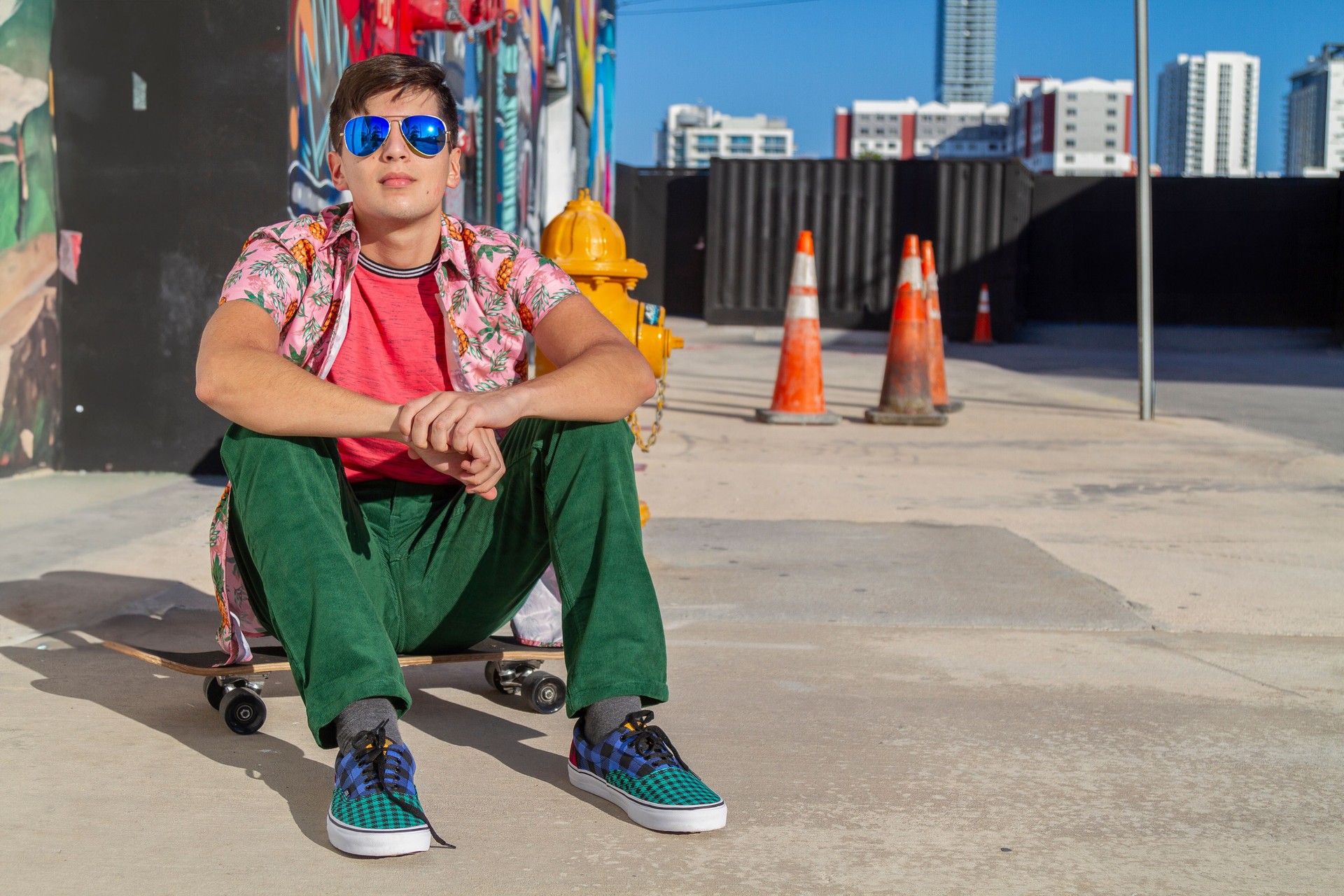 Portrait of young latin college university happy handsome male student, skater, Art Director, Graphic Designer, Designer enjoying his time in the United States taking a look around graffitis and installations arts in Wynwood District Miami Design District